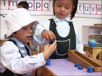 Nursery children using Montessori materials to learn at their own pace