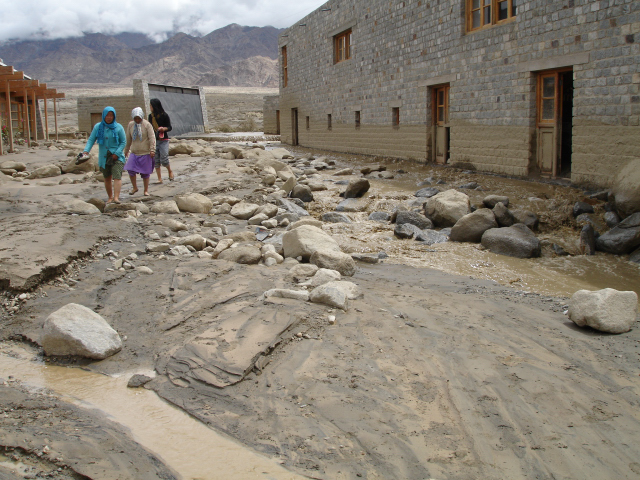 House mothers walking into front of Rancho's wall|<b>Barefoot house mothers walking in front of Rancho’s wall after the mudslide</b>
